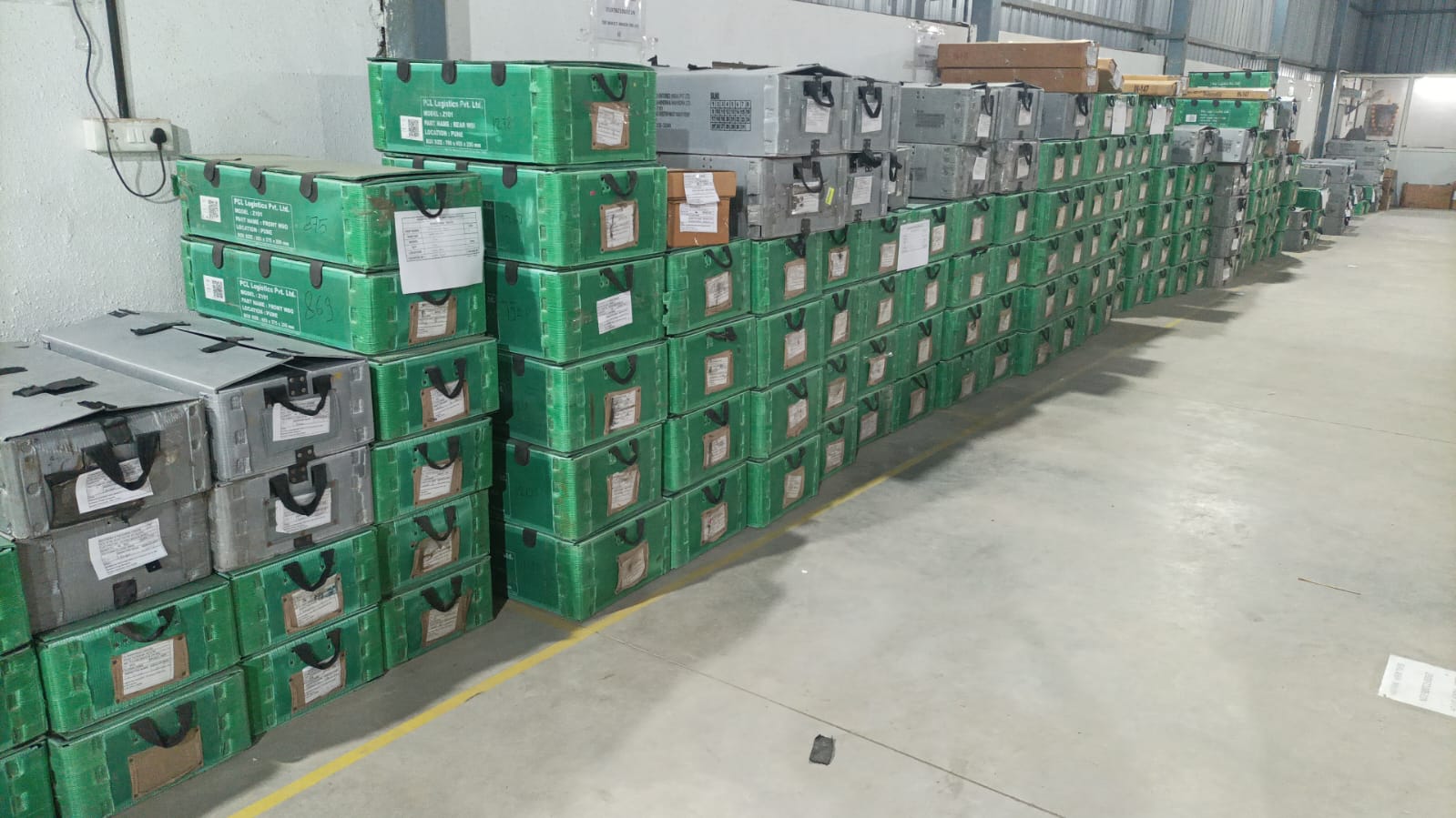 Original photograph of PCL green and grey returnable packaging organised in warehouse rows